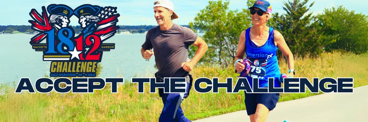 Two runners, a man and a woman, are shown mid-stride on a paved path next to a body of water. The race logo for the '1812 Challenge' is visible on the left, and the text 'ACCEPT THE CHALLENGE' is overlaid prominently across the image.