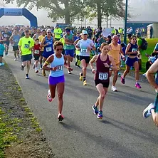 Runners starting a race with an archway in the background.