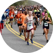 A group of runners are running on a road during a race, with yellow lines marking the lanes.