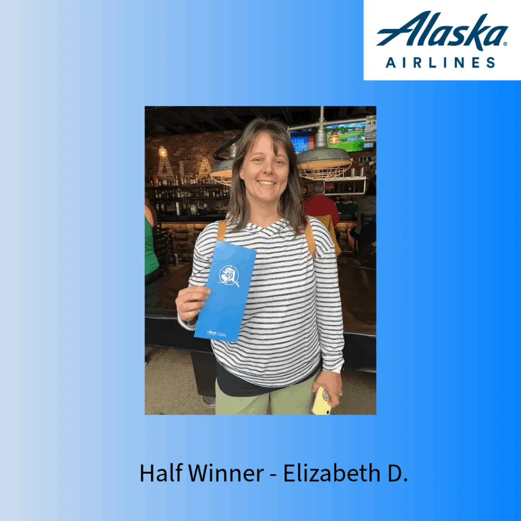 Half marathon winner Elizabeth D. holding a blue race program.
