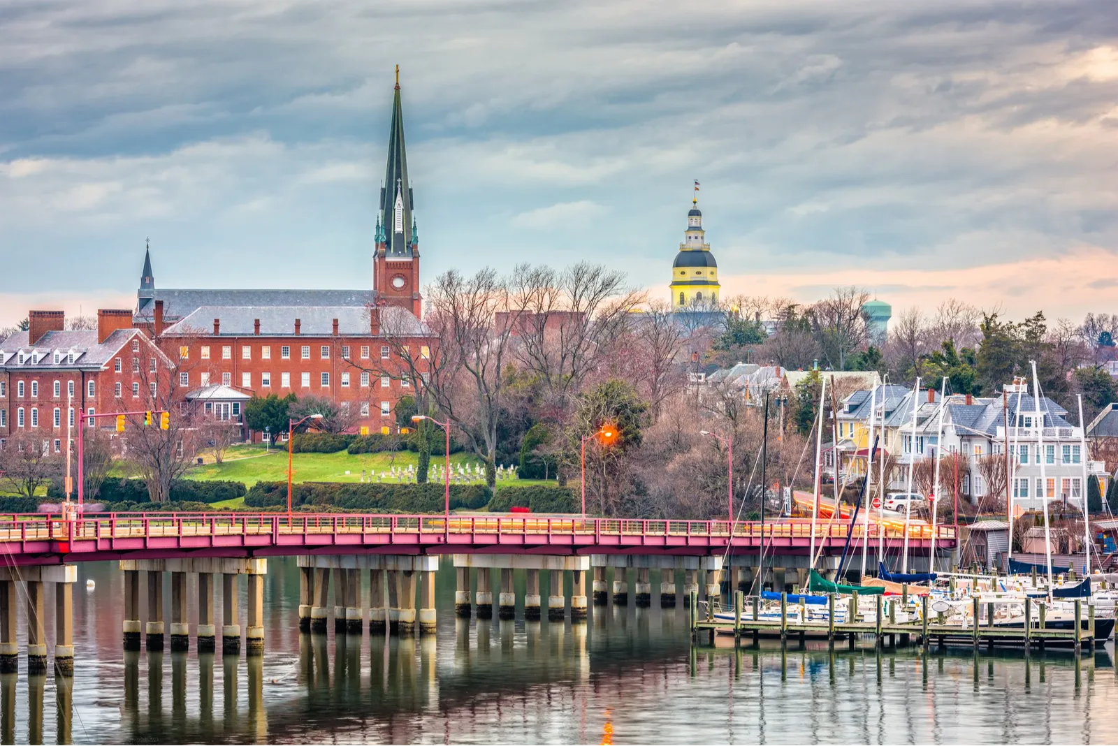 A scenic view of Annapolis, Maryland, with a bridge spanning the water and historic buildings in the background.
