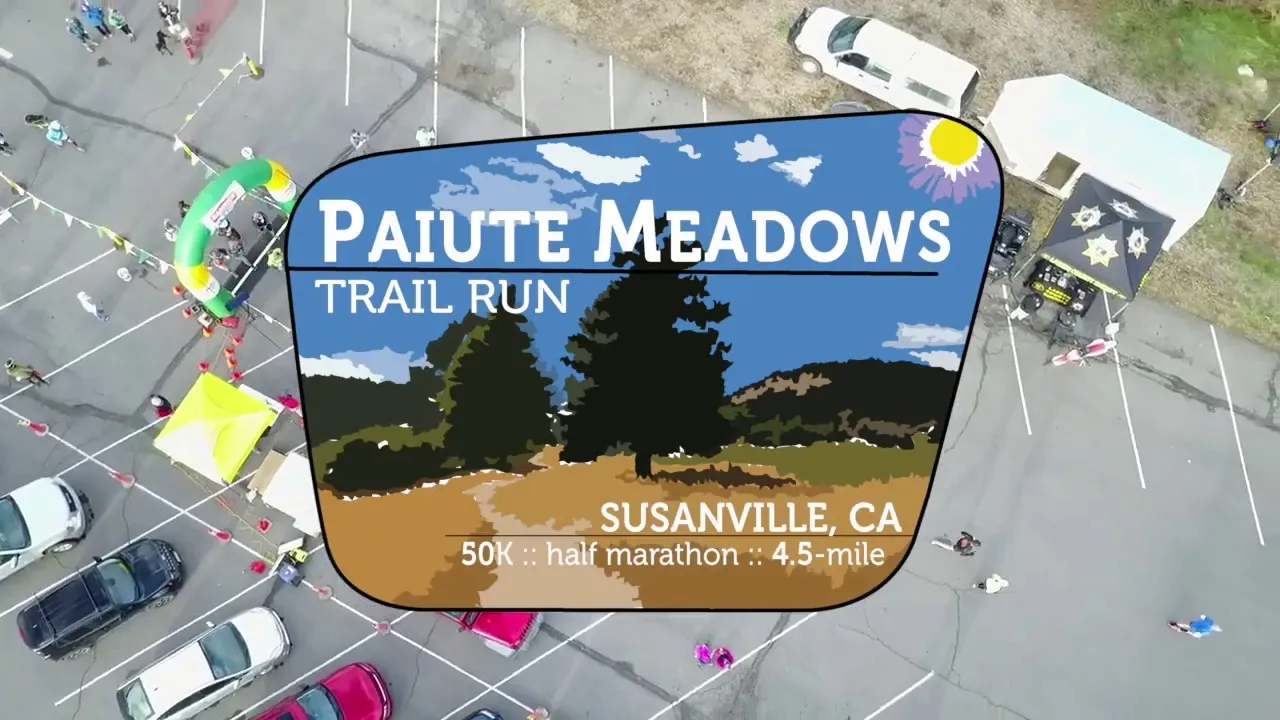 Aerial view of the Paiute Meadows Trail Run start line with runners gathered around a green archway.