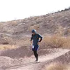 A solo runner pauses on a dusty trail during a race.