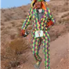 Runner in a colorful jester costume running on a desert trail.