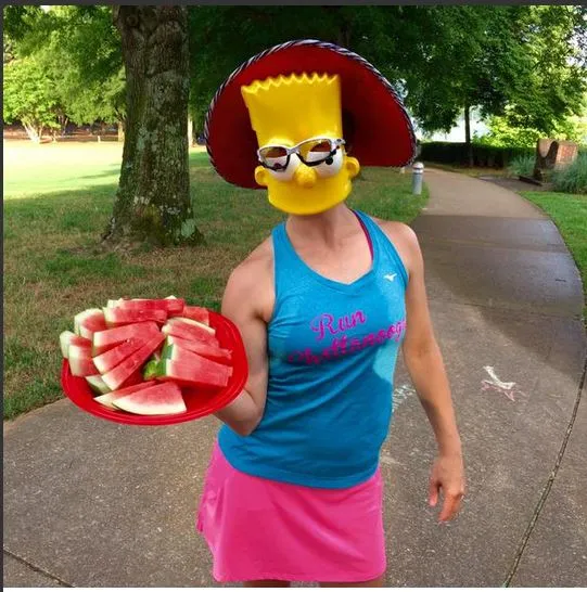 Runner in a Bart Simpson mask and a 'Run Chattanooga' tank top holding a plate of watermelon slices.