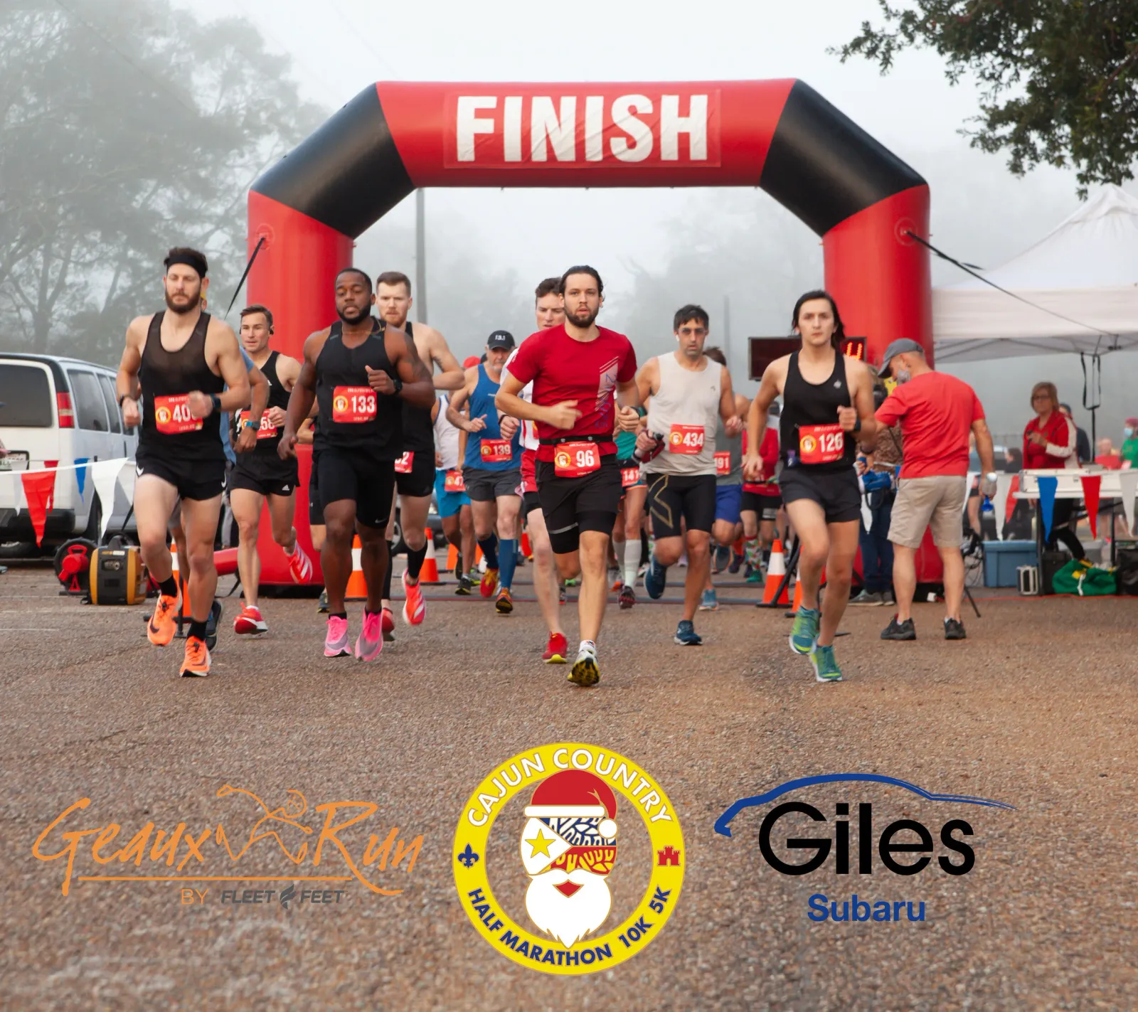 Runners crossing the finish line under a red and black inflatable arch at the Cajun Country Run.