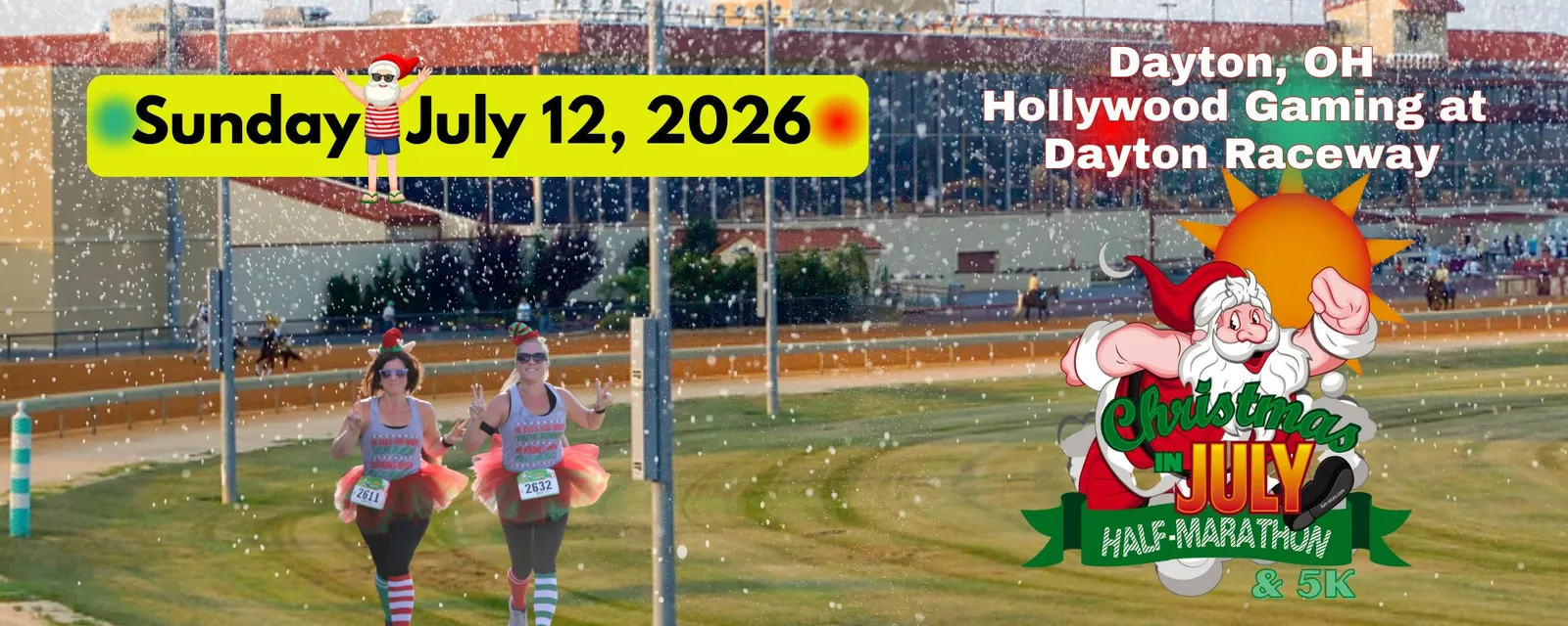 Two women in festive Christmas-themed running attire, including Santa hats and tutus, run towards the camera with smiles and peace signs, while fake snow falls around them. A banner in the background reads 'Sunday July 12, 2026' and 'Dayton, OH Hollywood Gaming at Dayton Raceway'.