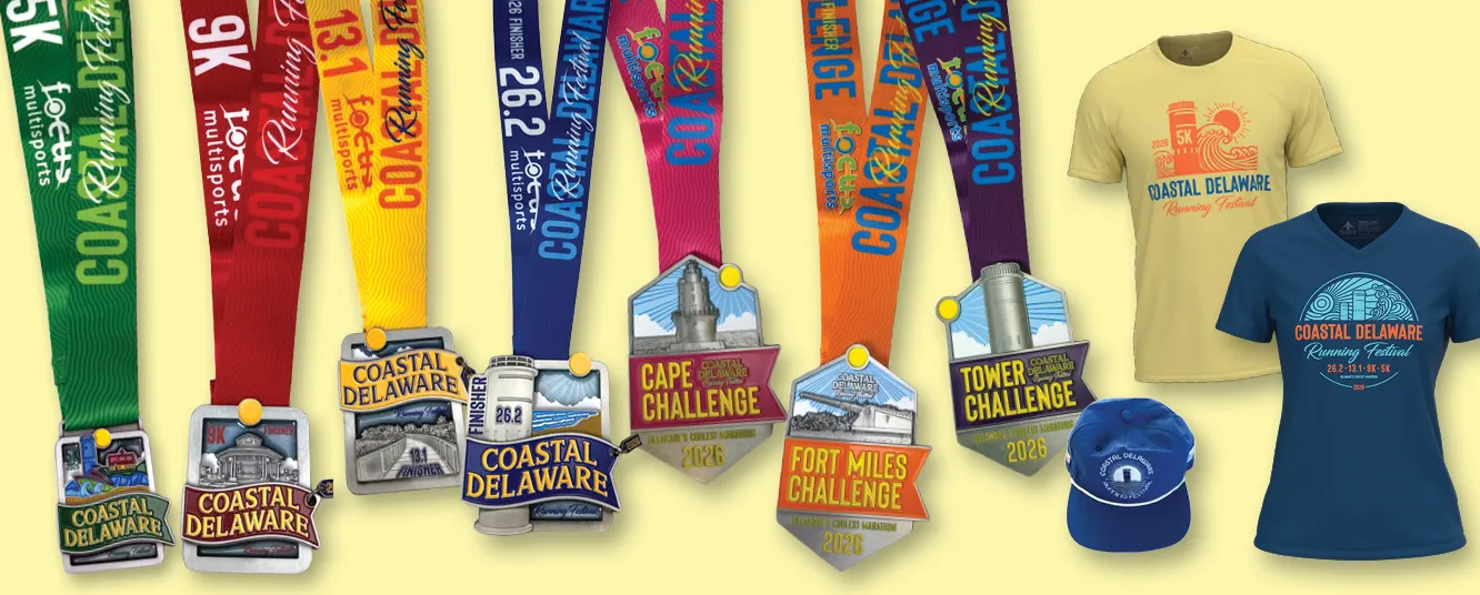 A collection of Coastal Delaware Running Festival medals and t-shirts, including 5K, 9K, 13.1, and 26.2 finisher medals, along with yellow and blue t-shirts and a blue baseball cap.