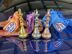 Three race medals in gold, silver, and bronze finishes, each with a unique design and colorful ribbons.