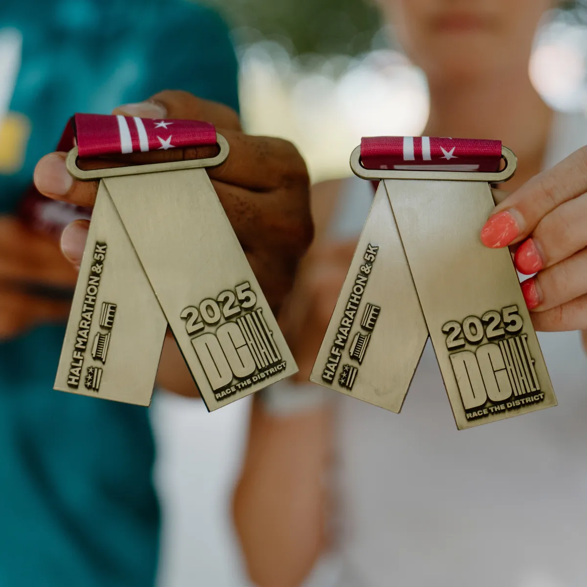 Two people holding up DC Half Marathon & 5K medals for 2025.