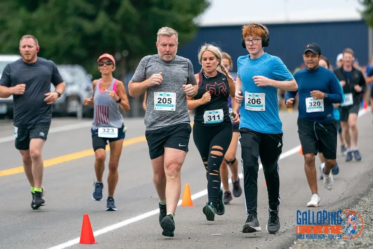 Runners participating in the Galloping Gertie Half Marathon, with bib numbers visible.