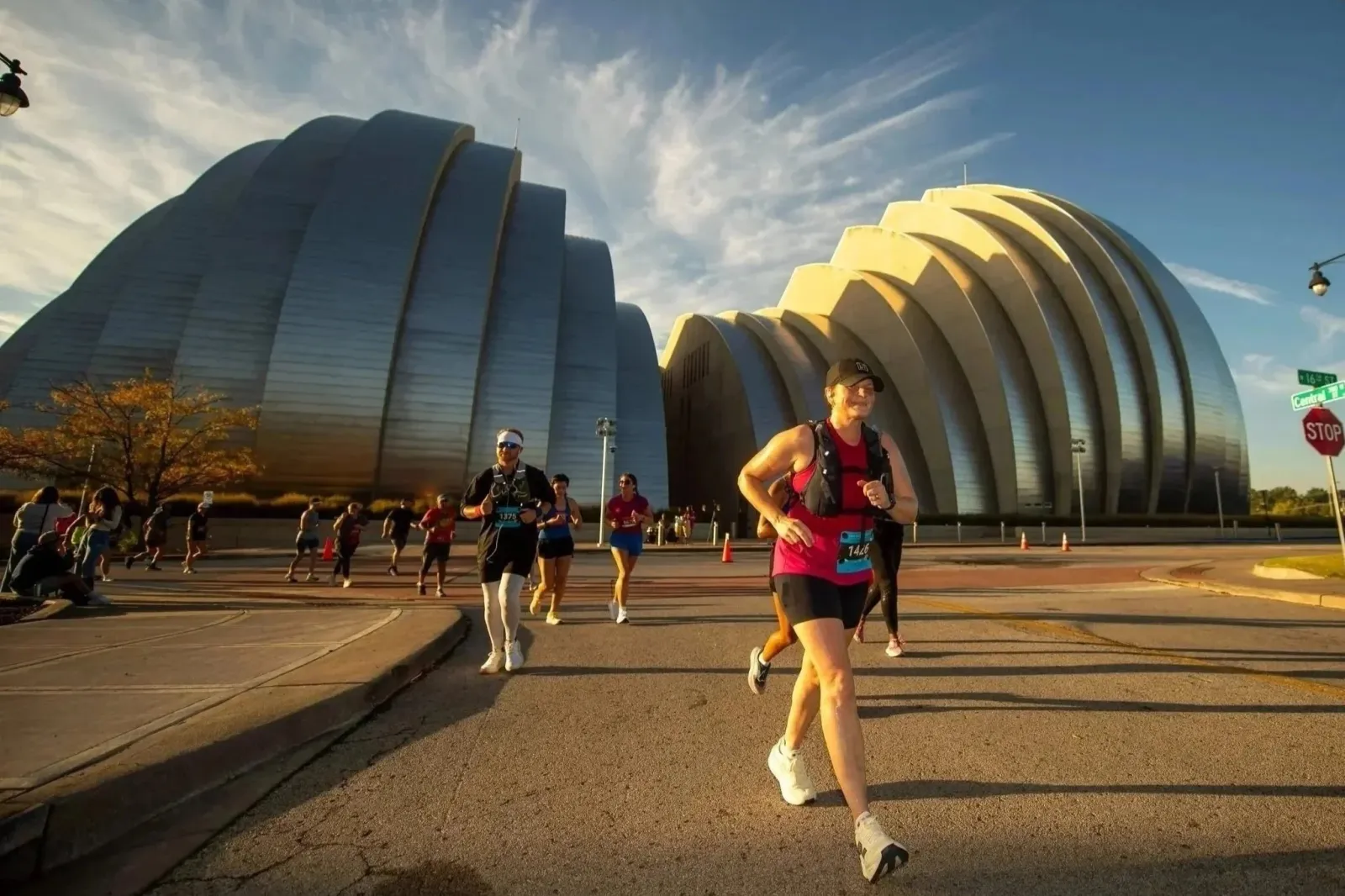Runners participating in a race with the Kauffman Center for the Performing Arts in the background.