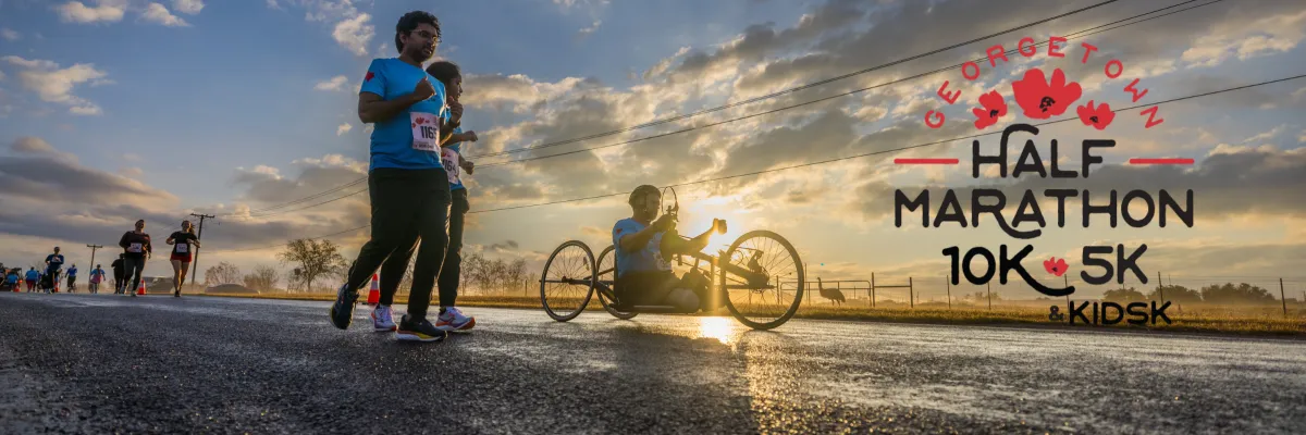 Runners participating in the Georgetown Half Marathon at sunrise, with a handcyclist also on the course.