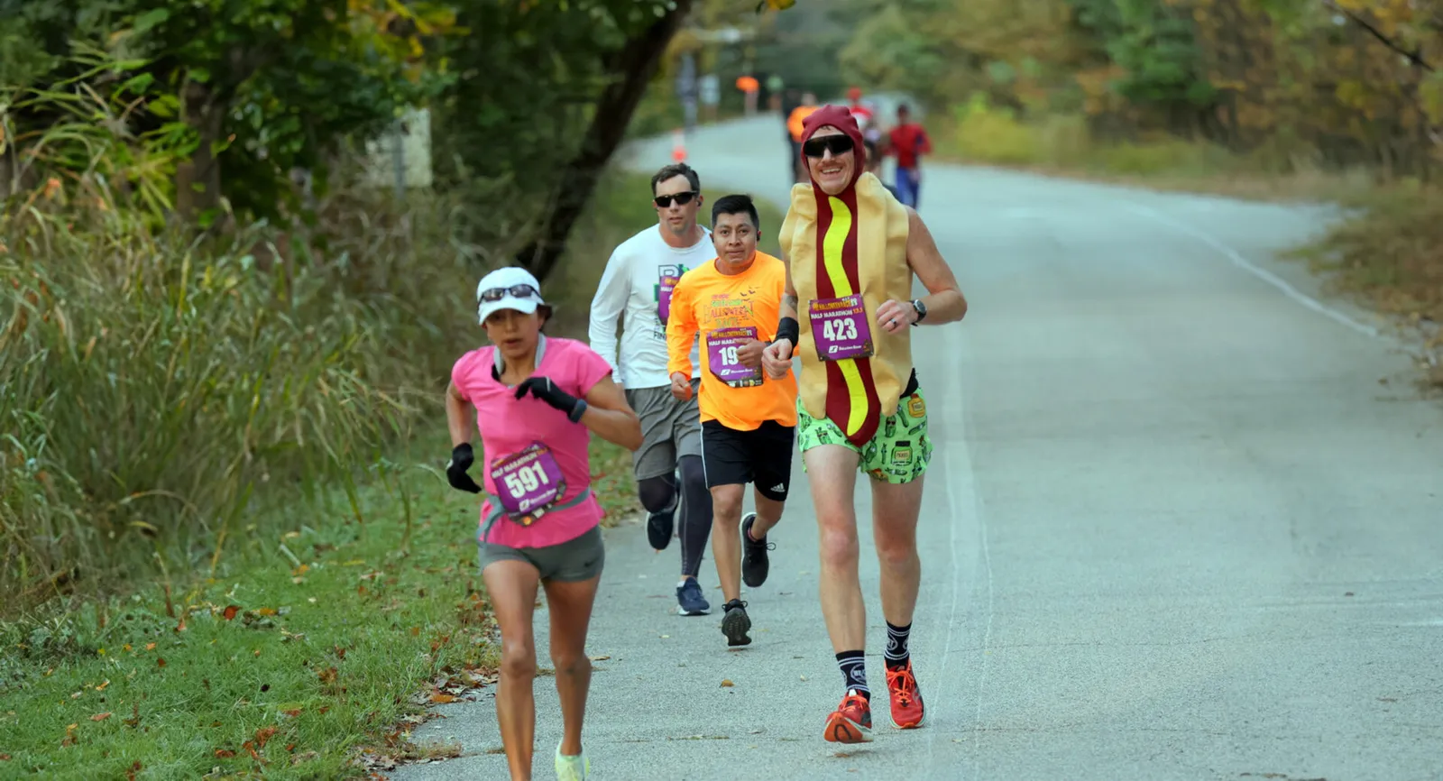 Runners participating in the Go St. Louis Halloween 10K/5K, with one runner dressed as a hot dog.