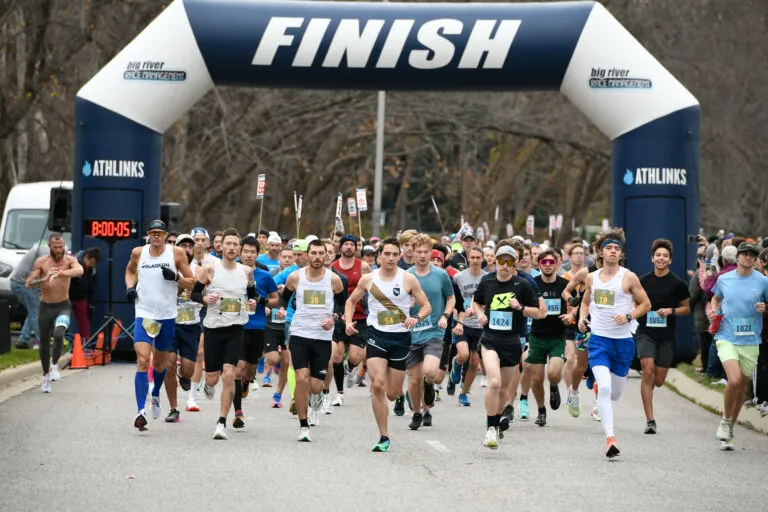 Runners in a race start line with a large inflatable arch that says 'FINISH'.