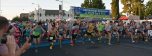Runners at the start line of a race, with a banner in the background.