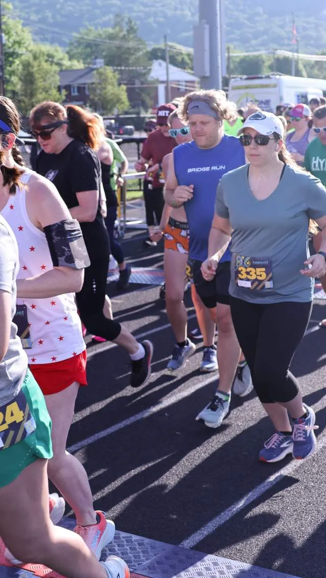 Runners in a race, with bib numbers visible, starting the event.
