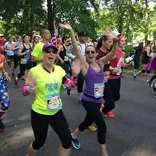 Runners waving and smiling during the Halloween Half Marathon.