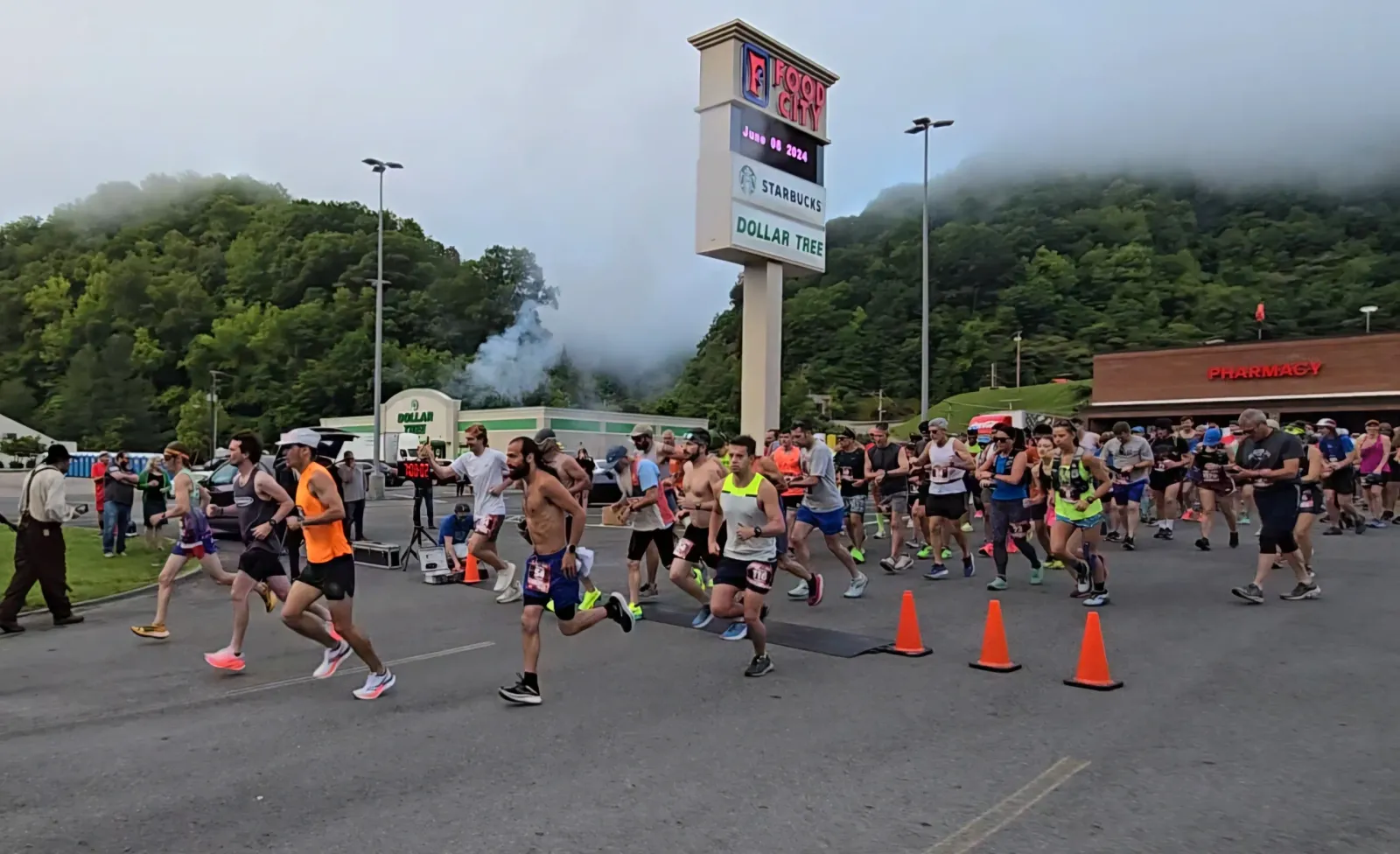 Runners starting a race with a crowd of participants and spectators in the background.