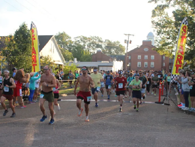 Runners starting a race, with start line banners and spectators.