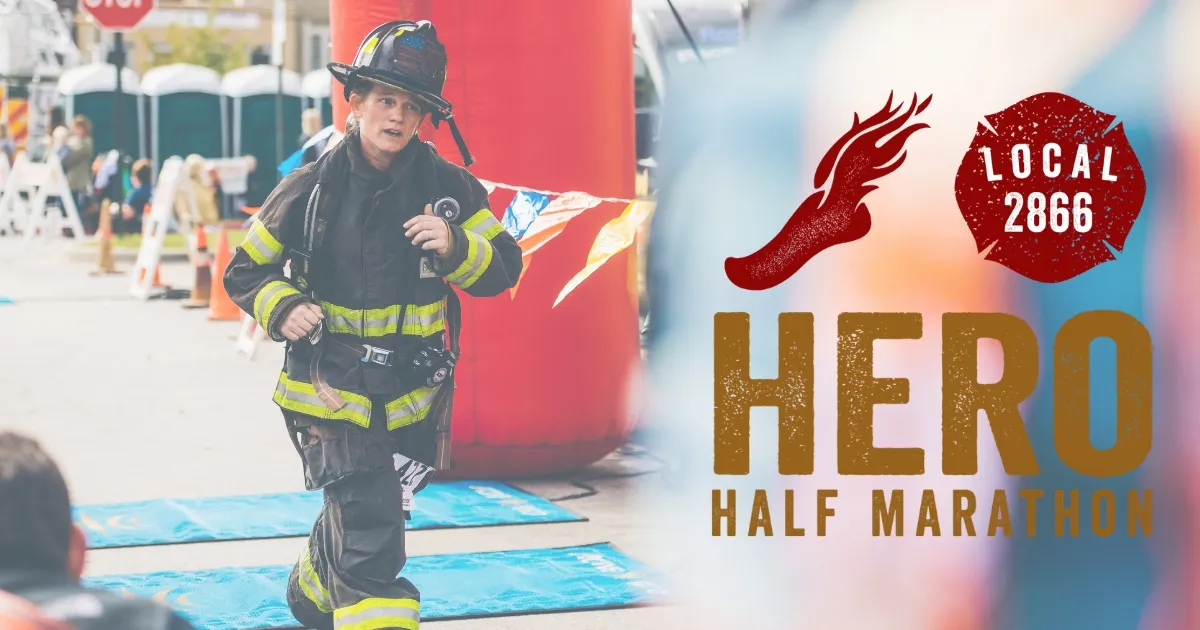 A firefighter in full gear runs towards the camera, with the race title 'HERO HALF MARATHON' overlaid on the right side of the image.