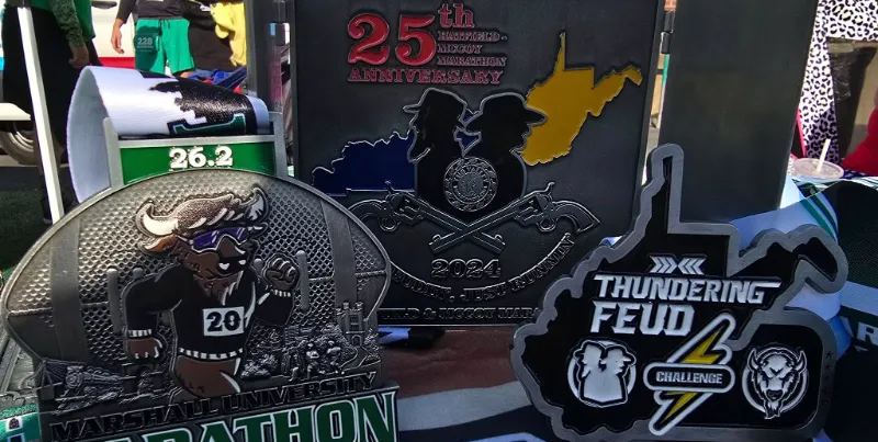 Collection of race medals for the Marshall University Marathon and the Hatfield-McCoy Marathon.
