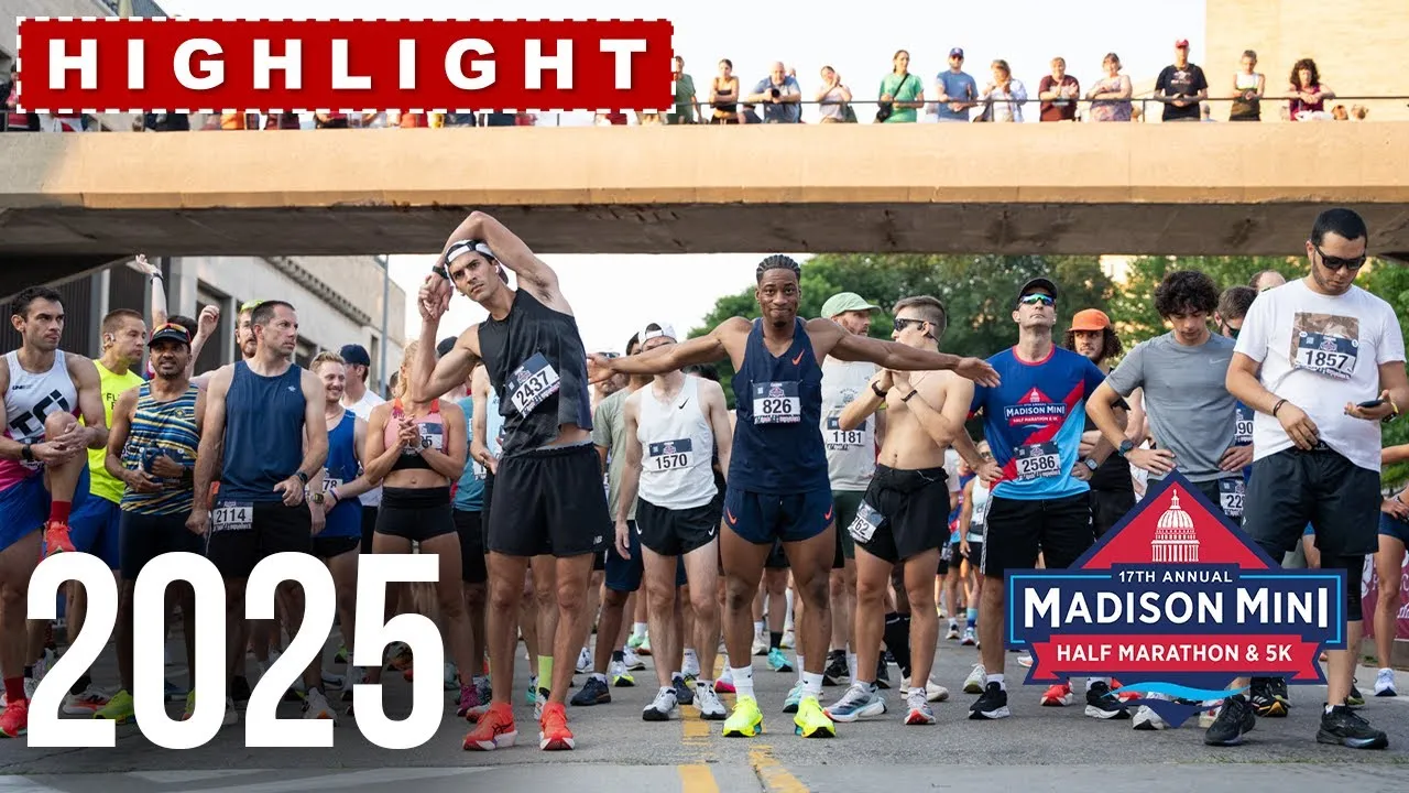 Runners in athletic wear stretching and posing at the start line of the Madison Mini Half Marathon & 5K, with spectators visible on an overpass above.