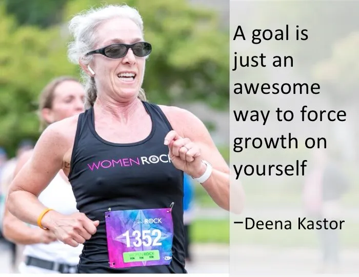 A woman with gray hair and sunglasses runs with a determined expression, wearing a black tank top with 'WOMEN ROCK' and bib number 1352. A motivational quote by Deena Kastor is overlaid on the right side of the image.