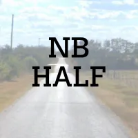 A paved road stretches into the distance under a partly cloudy sky, with the text "NB HALF" overlaid in bold black letters.