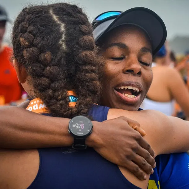 Two runners embracing with joy and relief after completing a race.