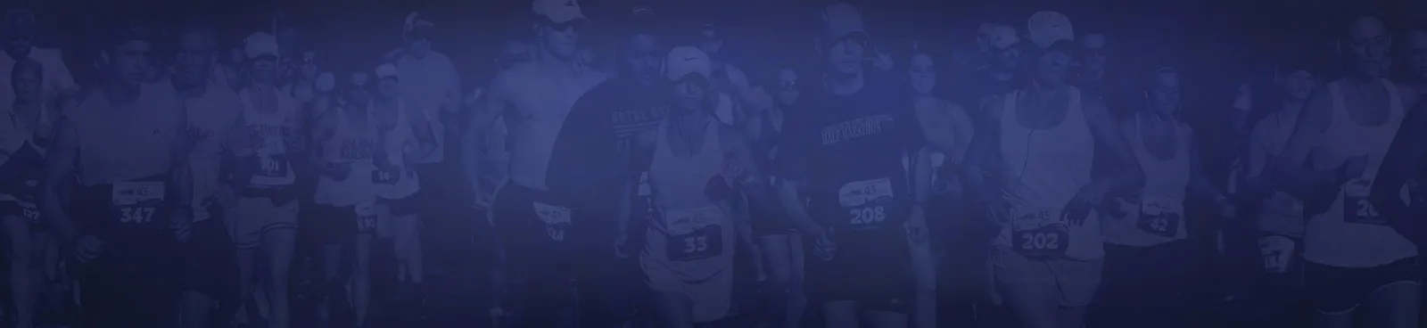 A group of runners at the start of a race, with bib numbers visible.