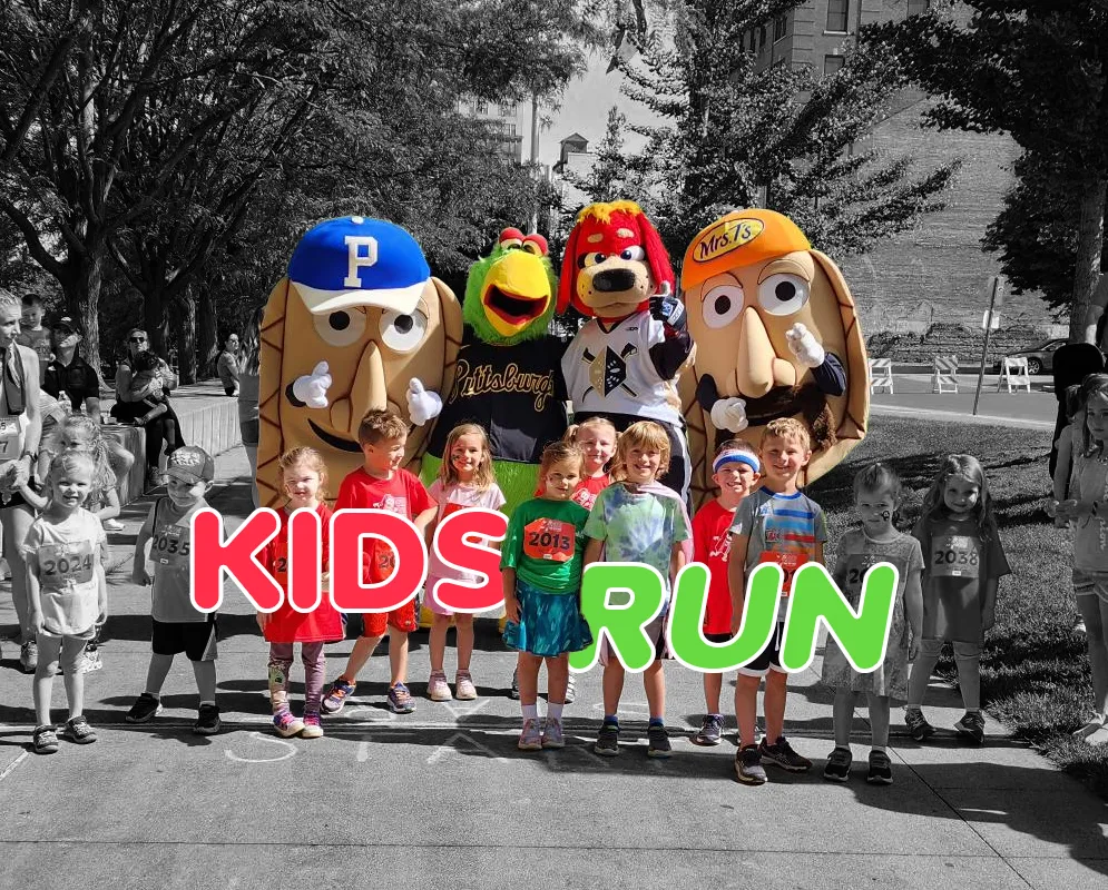 Children and mascots posing for a photo at a kids' run event, with the words "KIDS RUN" overlaid on the image.