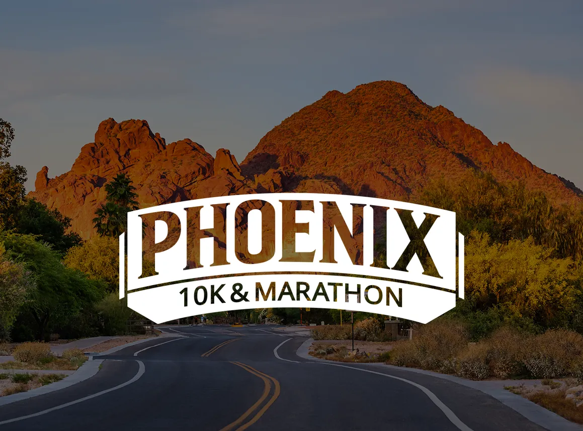 Scenic desert road with mountains in the background and a banner for Phoenix 10K & Marathon.