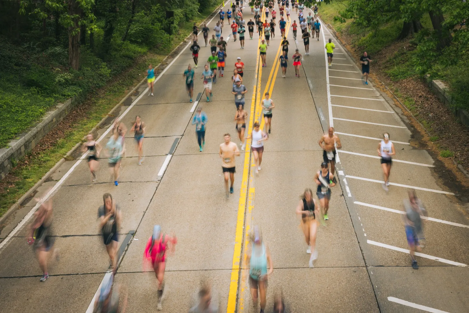 Runners on a road course, with motion blur indicating movement.