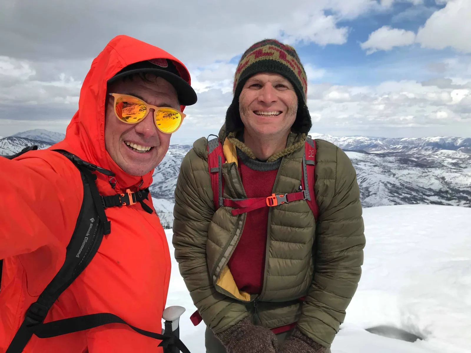 Two smiling people in winter gear take a selfie on a snowy mountain landscape during the Ponderosa Polar Challenge.