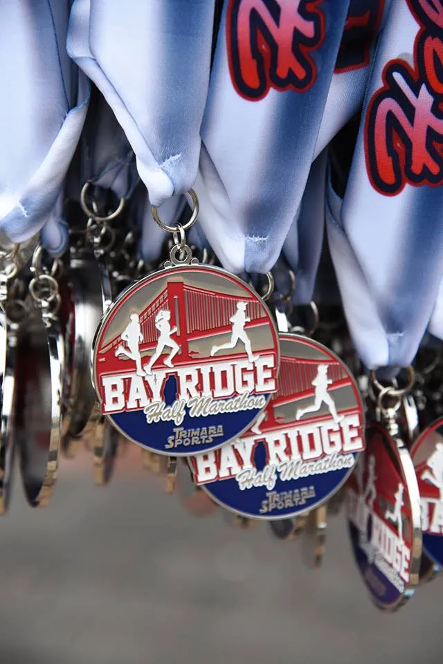 Close-up of Bay Ridge Half Marathon medals featuring runners and a bridge design.