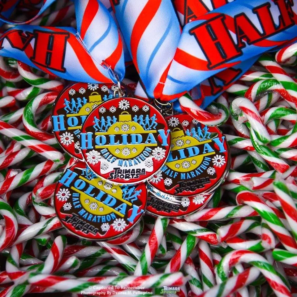 Close-up of several 'Holiday Half Marathon' medals resting on a bed of candy canes.