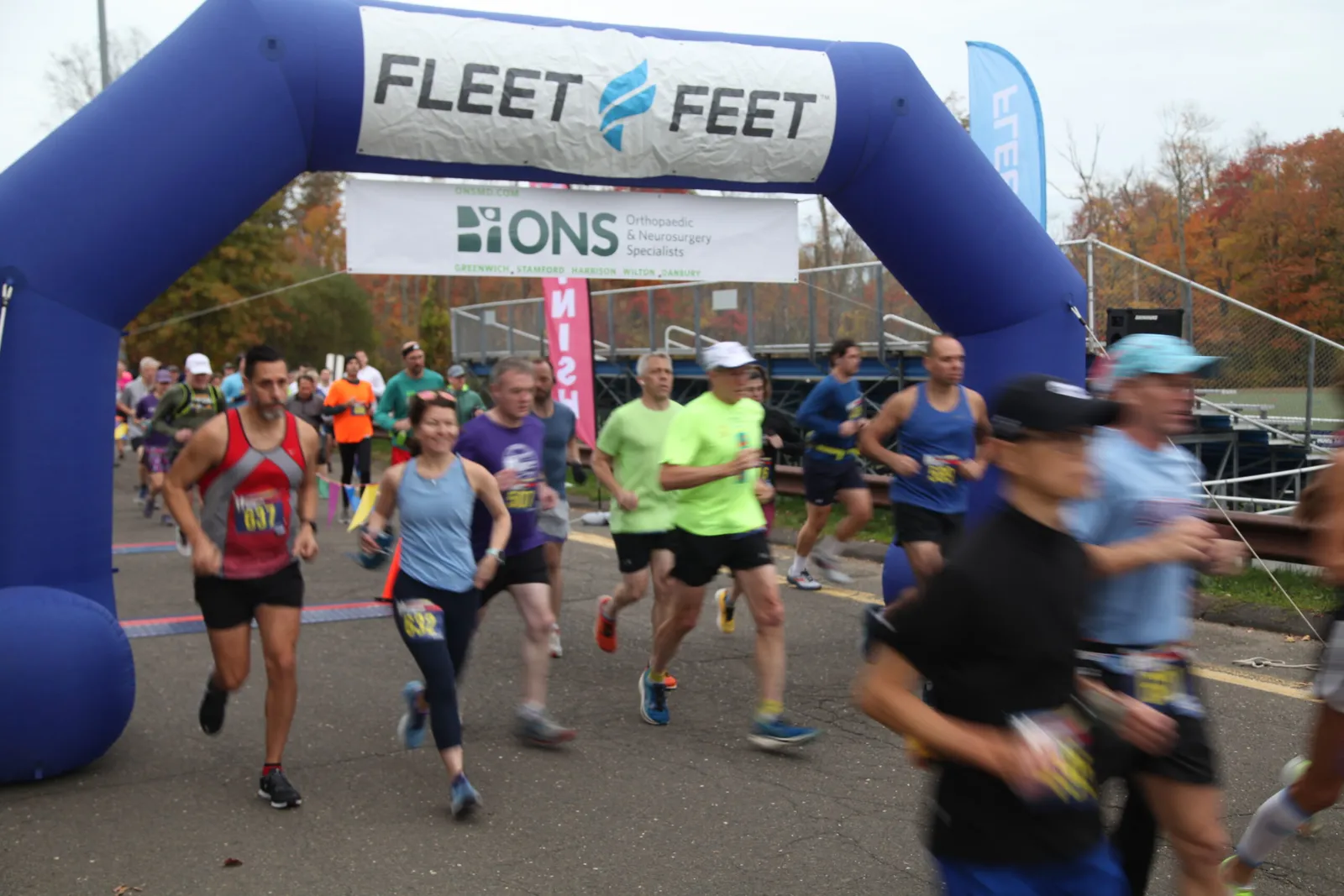 Runners crossing the start line under a blue inflatable arch at the Reservoir Run Half Marathon.