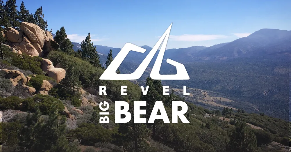 Scenic mountain view with Revel Big Bear logo and text overlay.