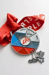 Revel Triple Reveler 2018 medal with a red ribbon and three small charms.