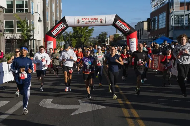 Runners crossing the start line under an inflatable archway at the Rock Reno Half Marathon.