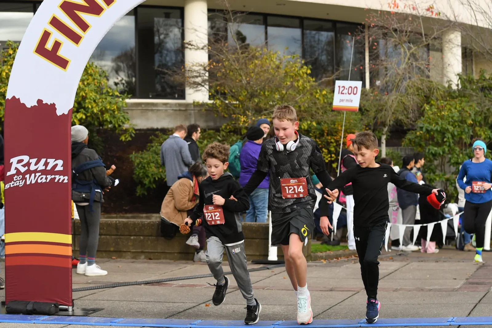 Young runners crossing the finish line at the Run to Stay Warm race.
