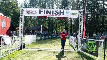 Runner crossing the finish line at the Silver Falls Trail Marathon.