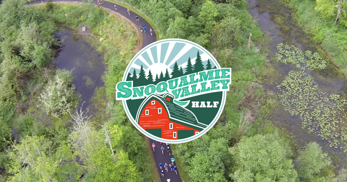 Runners on a paved path through a forest with the Snoqualmie Valley Half marathon logo overlaid.