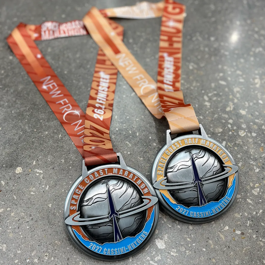 Two Space Coast Marathon and Half Marathon medals with their ribbons.