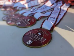 Close-up of St. Joseph Marathon medals with red and white ribbons.