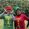 Two people in elf costumes, one wearing sunglasses, smiling at the camera.