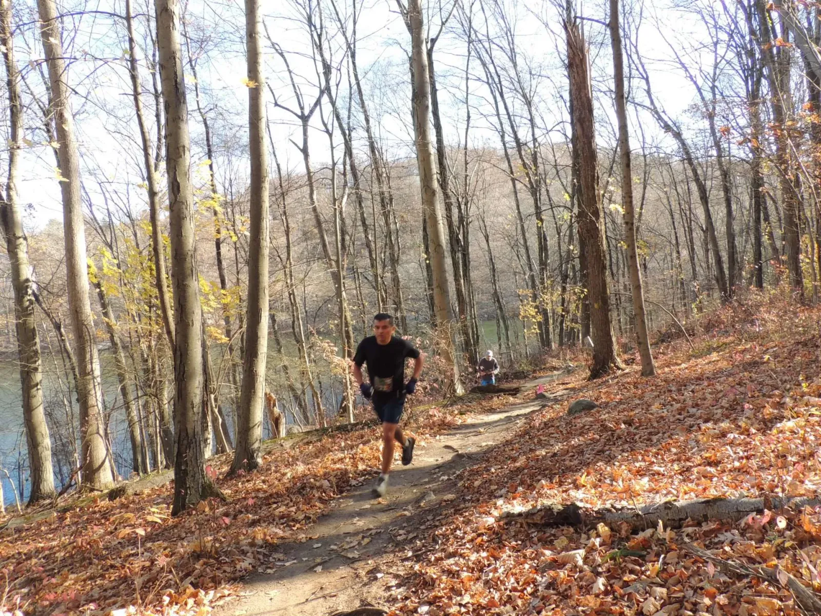 A runner on a wooded trail during a race.