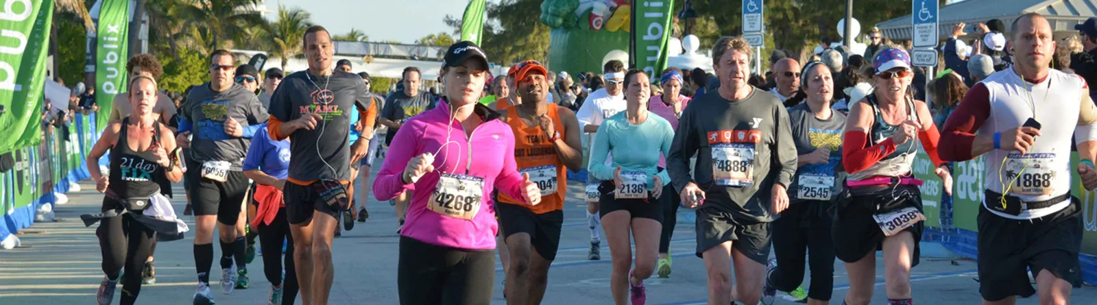 Runners participating in the Fort Lauderdale Running Festival, with spectators and sponsor banners visible.