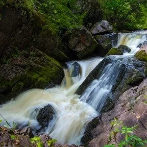 A scenic view of a waterfall cascading over rocks in a forest.